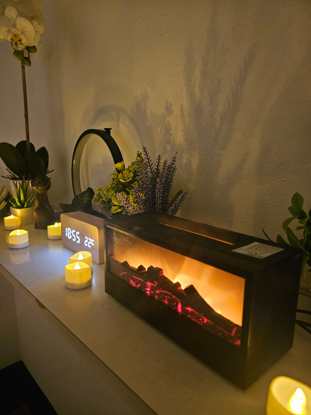 Gemütliche Atmosphäre mit Kerzenlicht und elektrischem Kamin