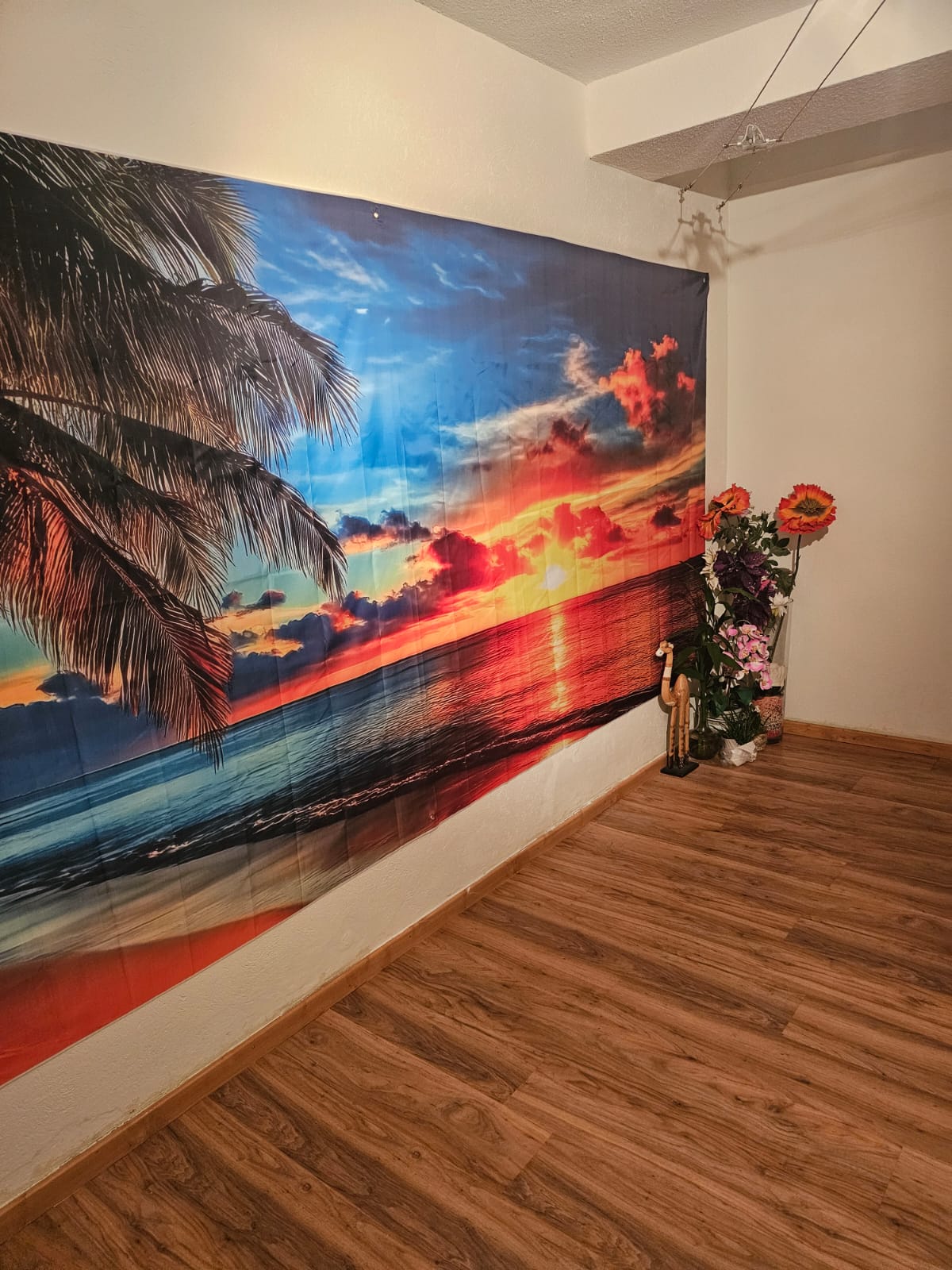 Behandlungsraum mit tropischem Wandbild und Holzboden